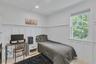 Bedroom with a decorative wall, wooden ceiling, a wainscoted wall, and an office area