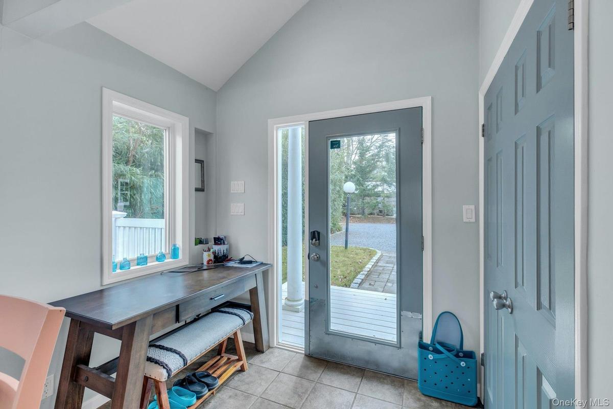 Entryway with lofted ceiling, healthy amount of natural light, and tile patterned flooring