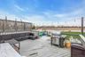 Wooden terrace featuring outdoor lounge area, a water view, and a grill