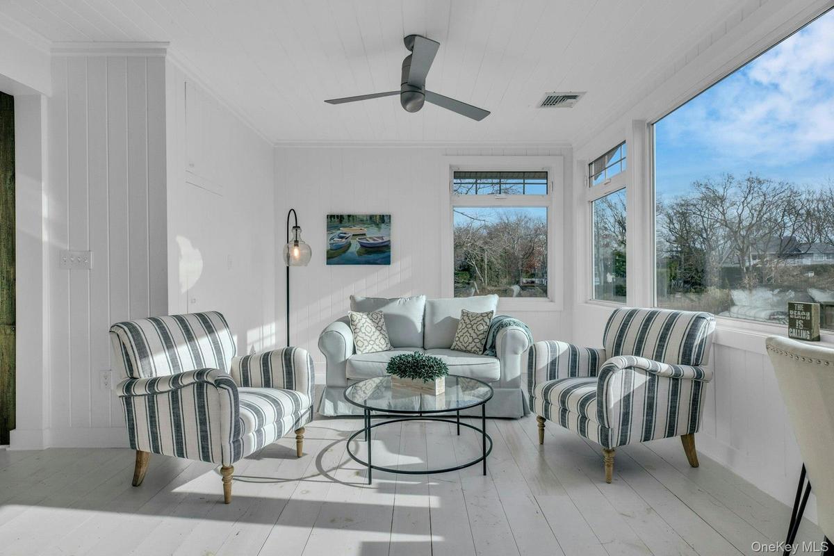 Sunroom / solarium featuring wood walls, wood-type flooring, and ornamental molding