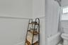 Bathroom featuring a wainscoted wall and shower / bathtub combination with curtain