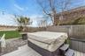 Deck with a covered hot tub, a water view, and a patio
