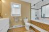 Bathroom with tiled shower / bath combo, a baseboard radiator, vanity, and tile patterned flooring