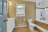 Bathroom featuring a baseboard radiator, vanity, tiled shower / bath combo, and light tile patterned floors