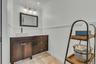 Bathroom featuring vanity, a wainscoted wall, and crown molding