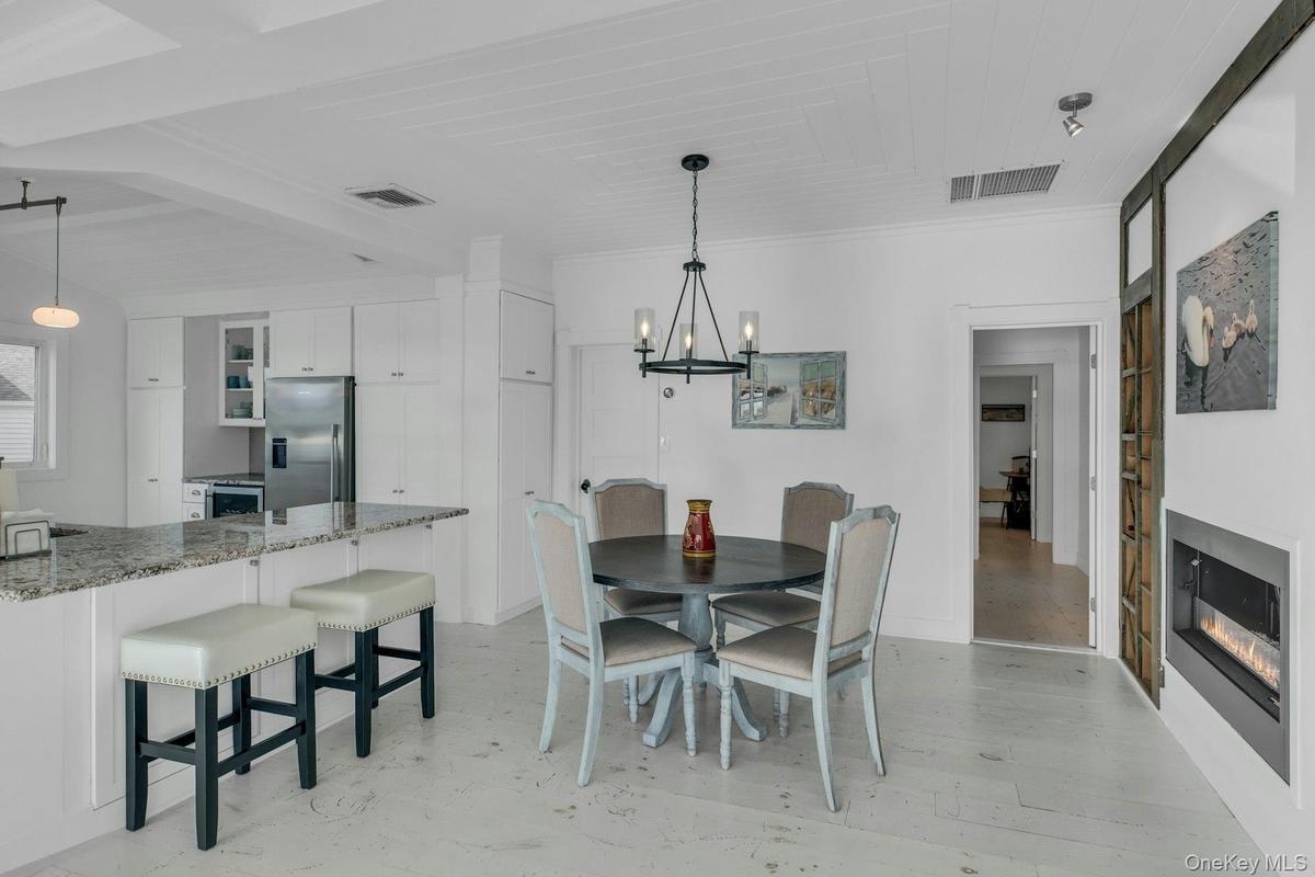 Dining space with a glass covered fireplace and a chandelier