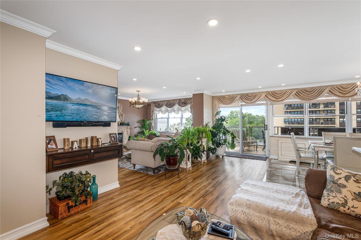 Living area featuring ornamental molding, recessed lighting, wood finished floors, a chandelier, and baseboards