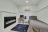 Bedroom featuring a decorative wall, wooden ceiling, a glass covered fireplace, wainscoting, and recessed lighting