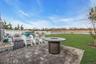 Fenced backyard featuring a patio area, a water view, and an outdoor fire pit