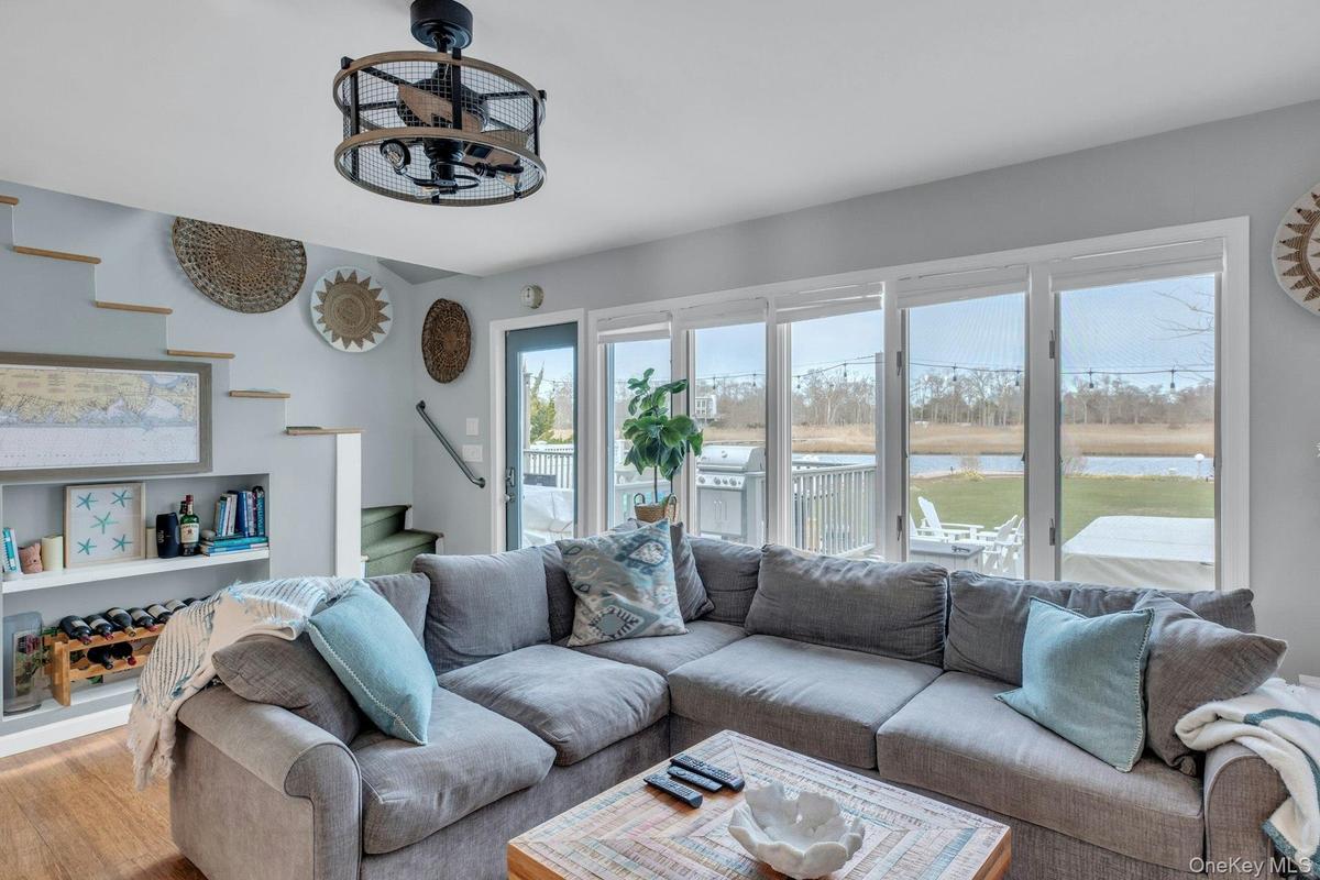 Living room featuring stairway, a water view, and wood finished floors