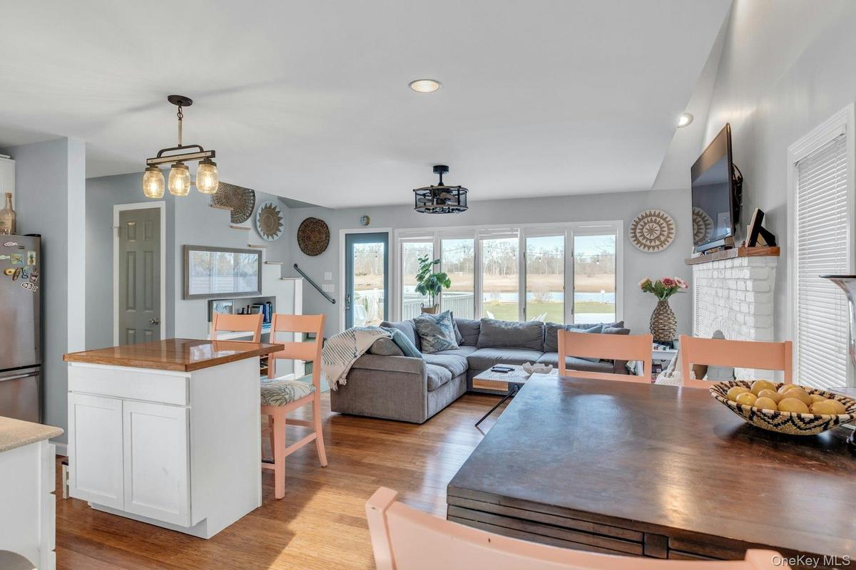 Kitchen featuring white cabinets, freestanding refrigerator, a kitchen island, hanging light fixtures, and recessed lighting