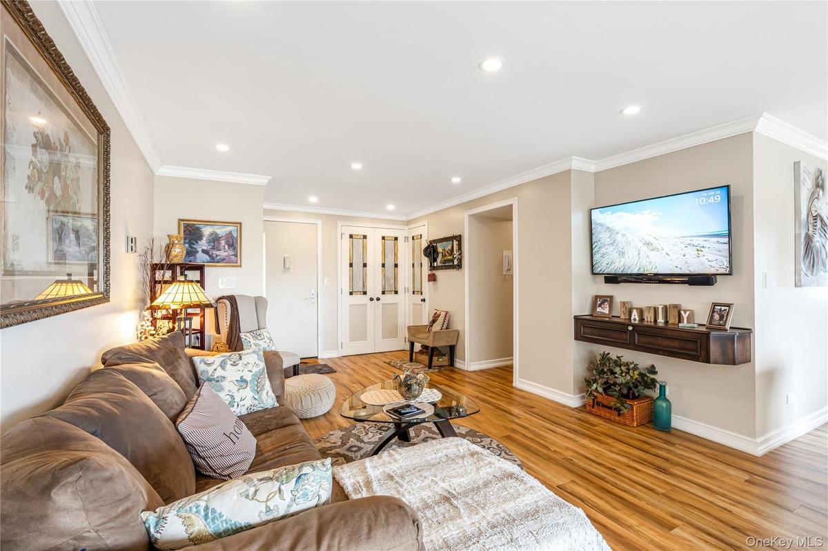 Living room featuring light wood finished floors, recessed lighting, ornamental molding, baseboards, and french doors