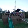 View of play area with a deck and a lawn