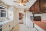 Kitchen featuring ceiling fan, light countertops, a wood stove, freestanding refrigerator, and a textured ceiling
