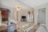 Carpeted living area with ceiling fan, arched walkways, a textured ceiling, and a baseboard heating unit