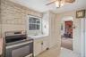 Kitchen featuring stainless steel range with electric cooktop, light countertops, freestanding refrigerator, a wood stove, and a ceiling fan