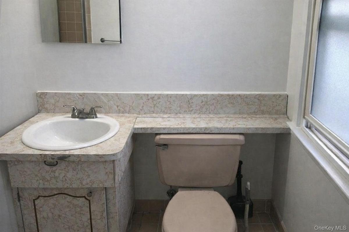 Half bathroom with vanity and tile patterned flooring
