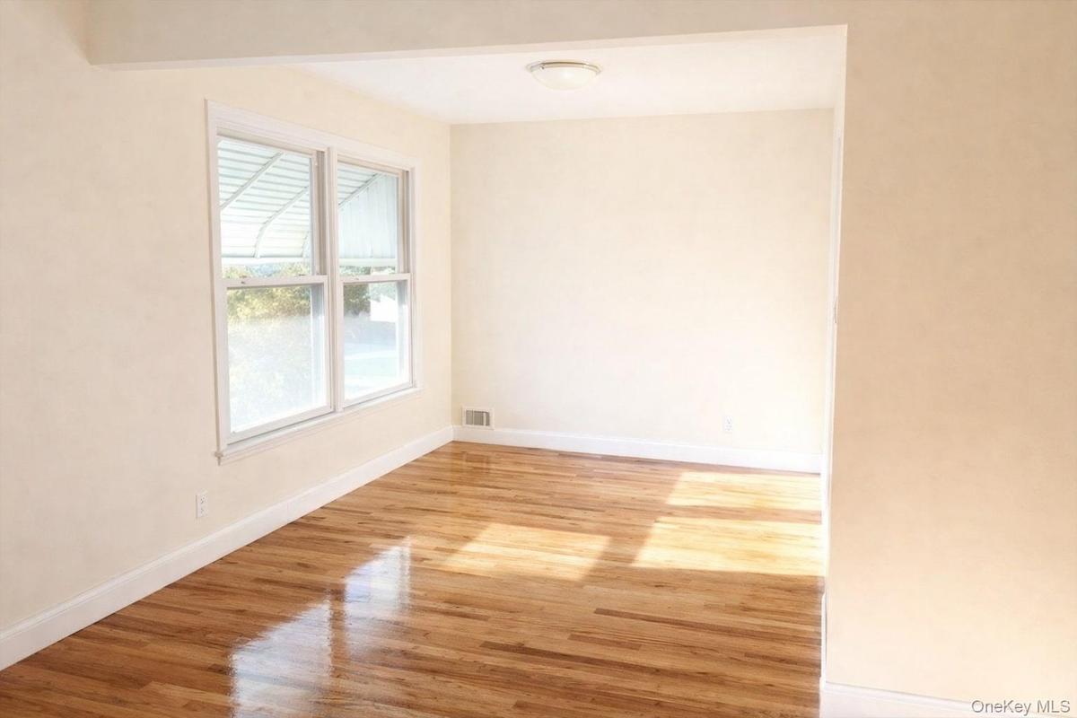 Spare room featuring light wood finished floors and baseboards