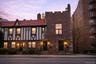 View of front facade at dusk featuring brick siding