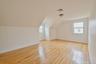 Additional living space featuring light wood finished floors and lofted ceiling