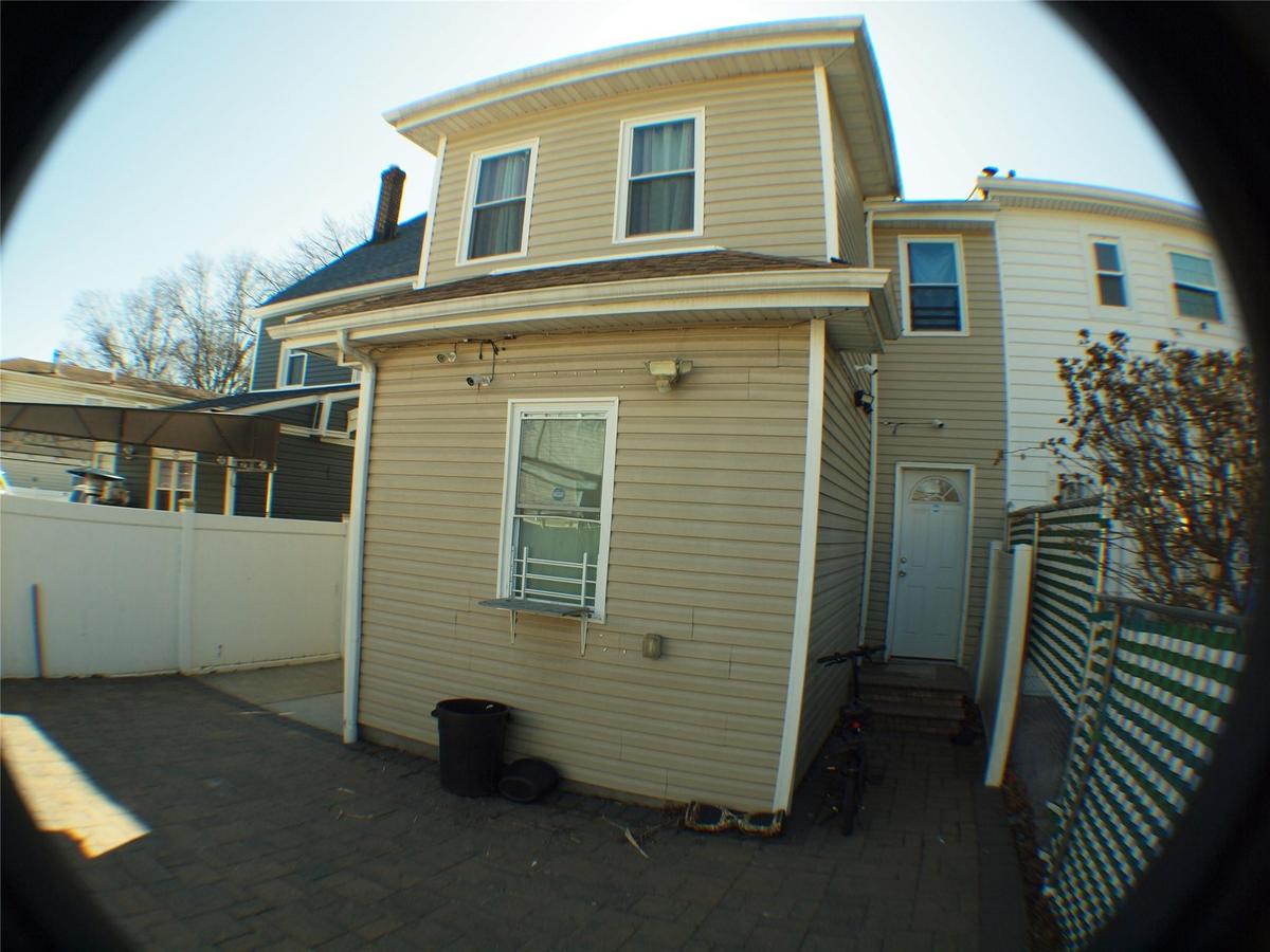 Rear view of house with entry steps and fence