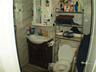 Half bathroom with vanity, tile walls, toilet, and tasteful backsplash