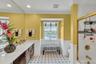 Bathroom with wainscoting, vanity, crown molding, shower / washtub combination, and light floors