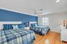 Bedroom featuring light wood-style floors, crown molding, and ceiling fan