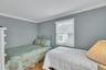 Bedroom with crown molding and wood finished floors