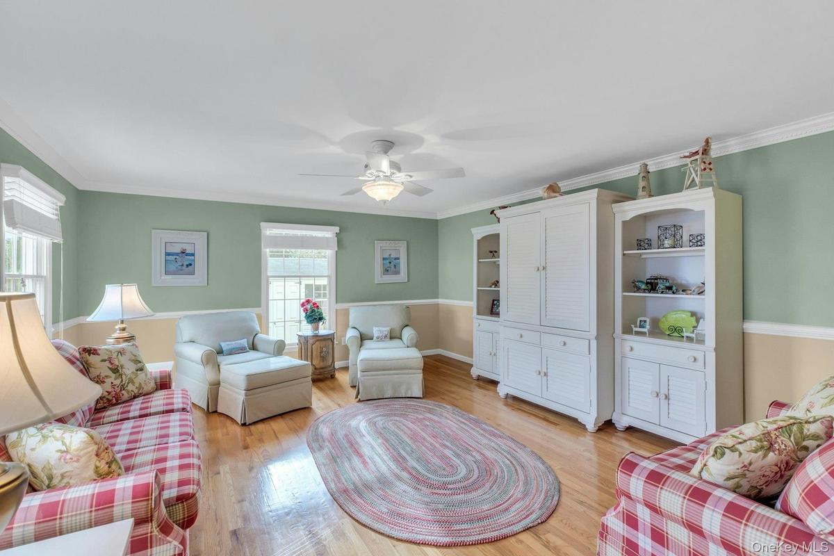 Living area with crown molding, light wood finished floors, and ceiling fan