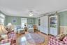 Living area with crown molding, light wood finished floors, and ceiling fan