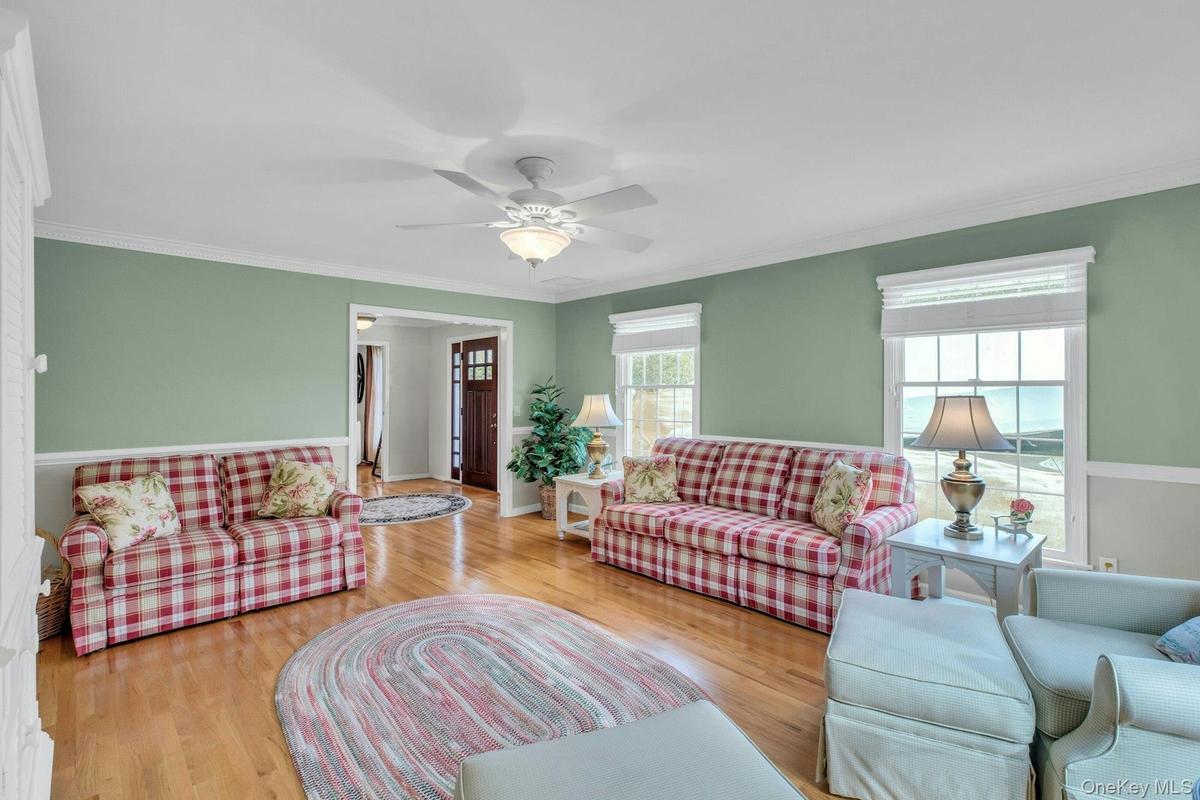 Living area featuring ornamental molding, wood finished floors, and ceiling fan