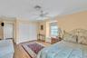 Bedroom featuring ornamental molding, a closet, ceiling fan, and light wood-style floors