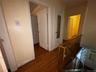 Hallway featuring an upstairs landing and dark wood-type flooring