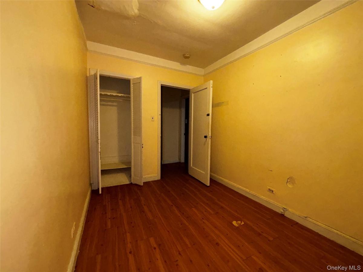 Unfurnished bedroom with dark wood finished floors and a closet
