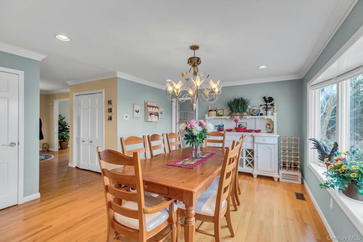 Dining area with ornamental molding, light wood-type flooring, recessed lighting, and a chandelier
