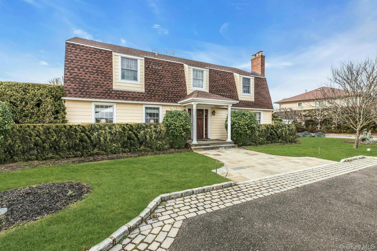 Dutch colonial featuring a gambrel roof, a shingled roof, and a front yard