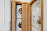 Laundry area with stacked washer and clothes dryer and recessed lighting