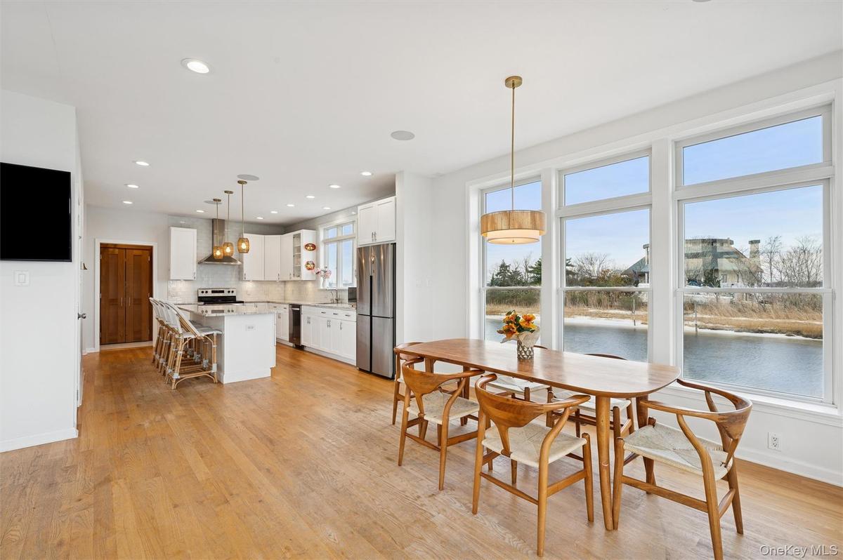 Dining space with recessed lighting, light wood-type flooring, and a water view