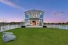 Back of property at dusk featuring a fenced backyard, a balcony, and a patio