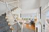 Entrance foyer featuring stairs, a high ceiling, wood finished floors, a water view, and recessed lighting