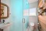 Bathroom featuring tile walls, a shower stall, and tile patterned flooring