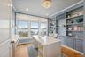 Office area featuring light wood-style flooring, a water view, crown molding, a textured ceiling, and recessed lighting