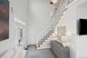 Foyer entrance with stairway, a towering ceiling, and wood finished floors