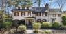 View of front of property with stone siding and a chimney