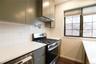 Kitchen featuring appliances with stainless steel finishes, sage green cabinetry, light stone counters, backsplash, and under cabinet range hood
