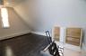 Finished attic space with permanent stairs from the 2nd floor, large windows and custom cabinetry built into the wall.