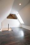 Additional living space with vaulted A-frame walls, recessed lighting, wood finished floors, and large window providing natural light. Background incl