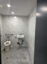 Bathroom with sink, toilet, and tile walls