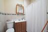 Full bathroom featuring tile walls, toilet, vanity, and a shower with shower curtain